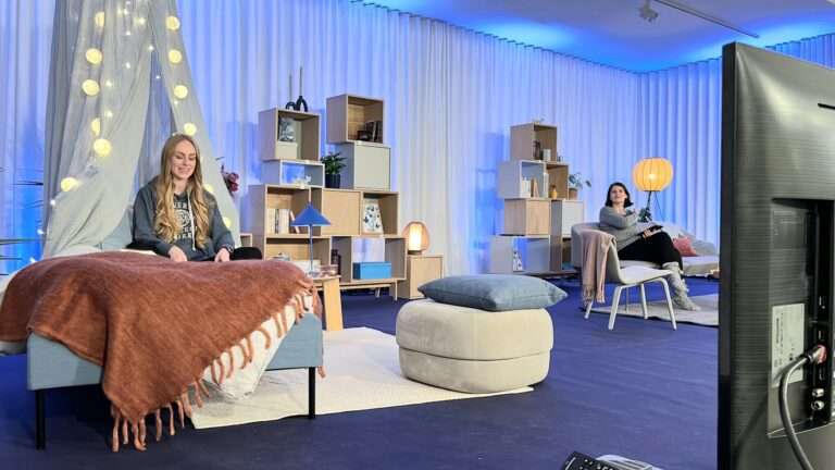 Eine Frau sitzt lächelnd auf einem Bett und liest ein Buch bei dem Event tolino StoryDays 2021