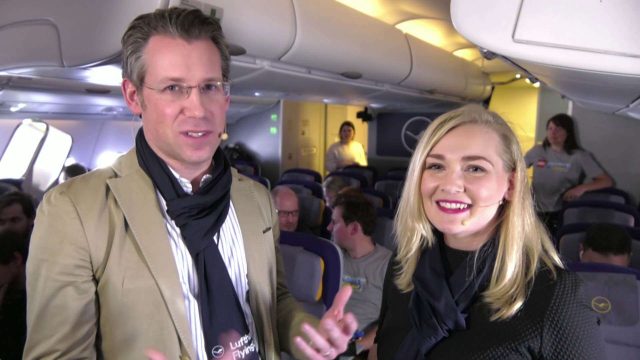 Zwei Menschen führen in einem Flugzeug ein Interview.