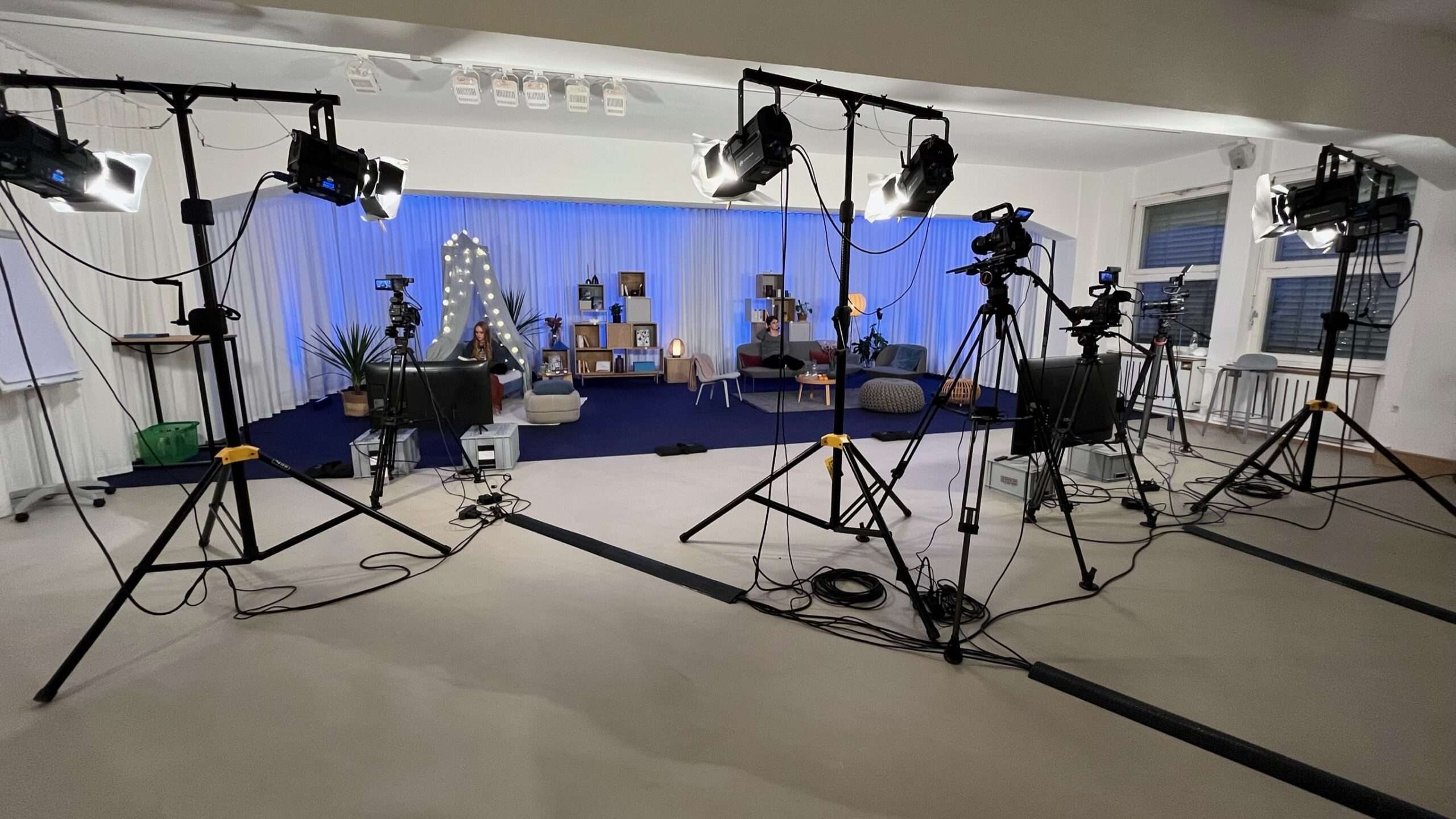 In einem Studio sind mehrere Kameras und Beleuchtung auf ein Set der hybriden Veranstaltung tolino StoryDays gerichtet